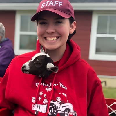 staff with a baby goat tucked in hoodie